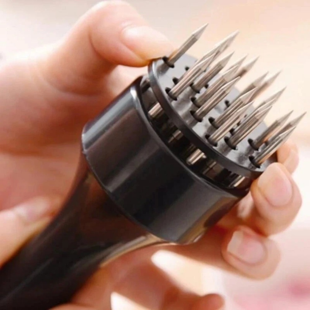 The 21 stainless steel needles of the tenderizer held up close in one hand