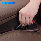Hand sliding a car key fob into the storage slot of the gap filler beside the seatbelt buckle