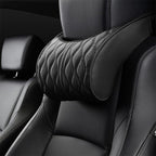 Close-up of the black neck pillow on the headrest, showing the curved bone shape and quilted stitching.