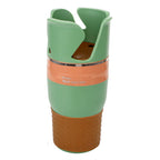 White-background front view of the green and orange multi cup holder on its brown dotted silicone base.