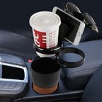 Car multi cup holder in use on a centre console, gripping a paper coffee cup, phone, sunglasses and a travel mug.