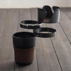Black and brown multi cup holder on a wooden floor, two swing-out rings extended and the body shown upright.