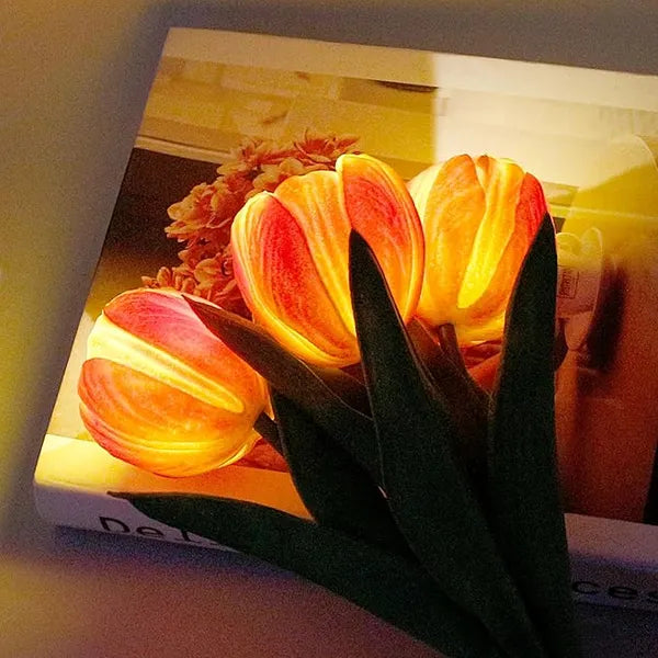 Close-up of the glowing orange tulip heads of the LED tulip lamp