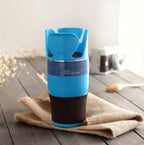 Blue cup holder styled on a wooden table with hessian cloth and dried flowers, camera blurred behind.