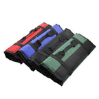 Three rolled-up canvas tool bags fanned out together in red, blue and green.