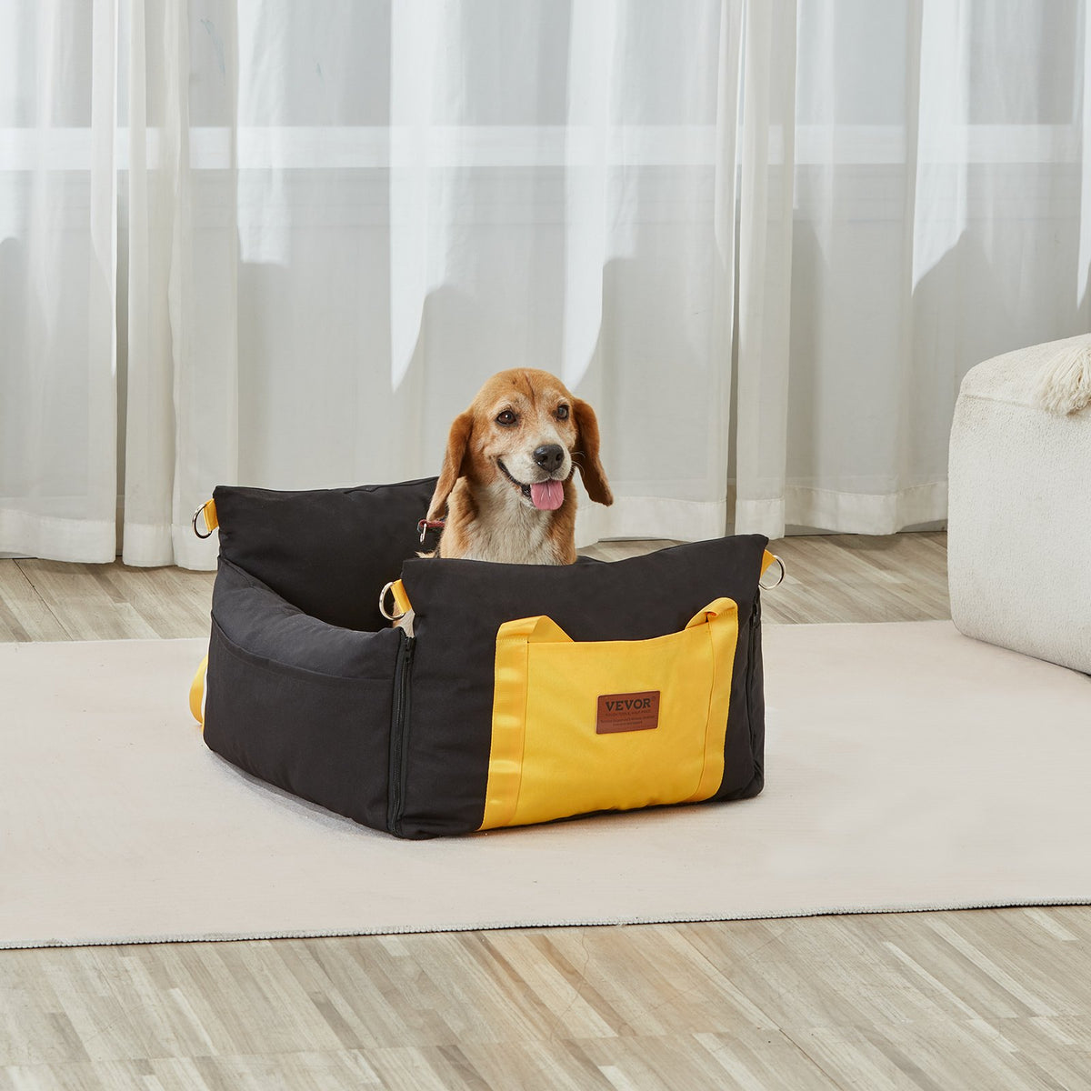 A beagle sitting inside the black and yellow booster seat in a living room